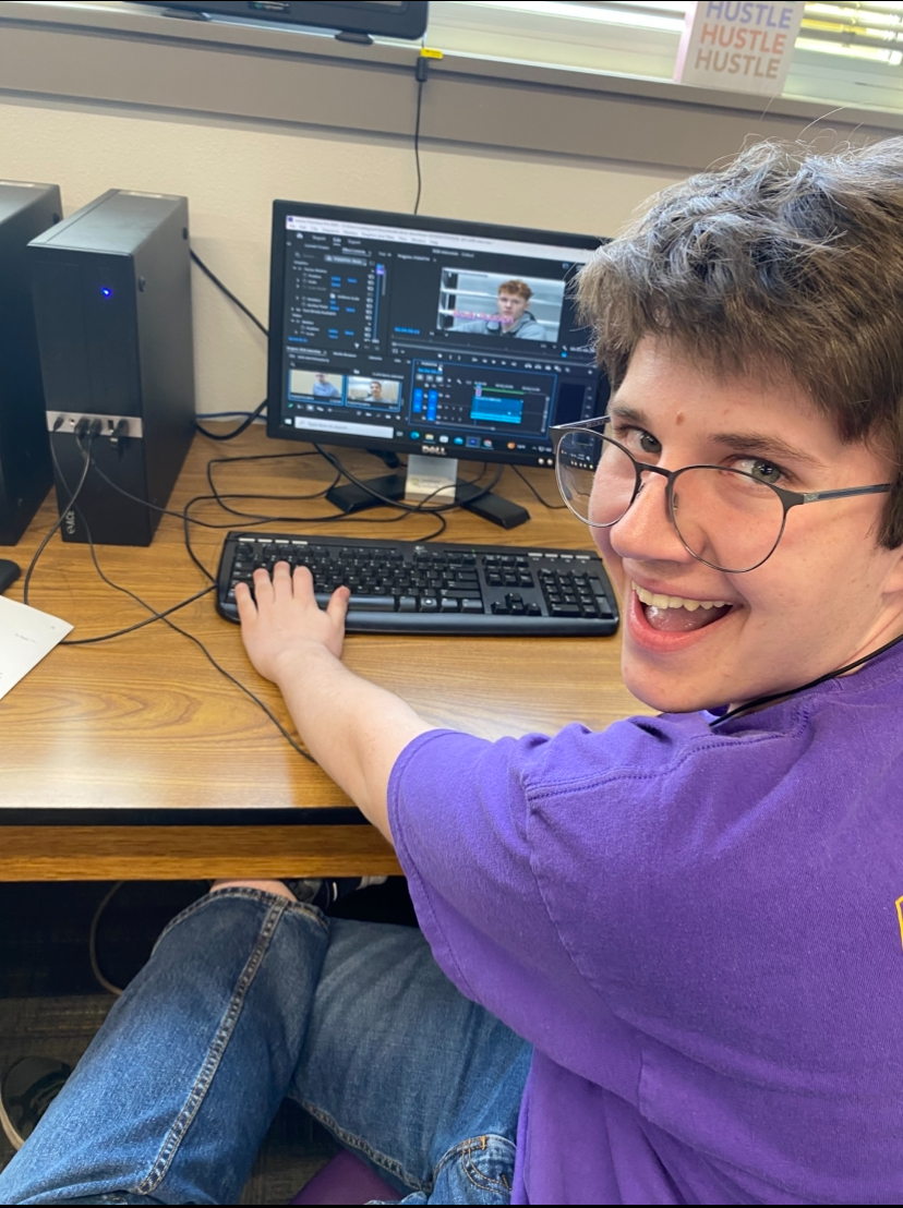 Grant Webb poses in front of his computer while working hard on work.
